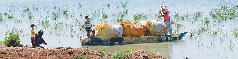 Local people cross the flooded Hawizeh Marshes, near the Majnoon project in Iraq